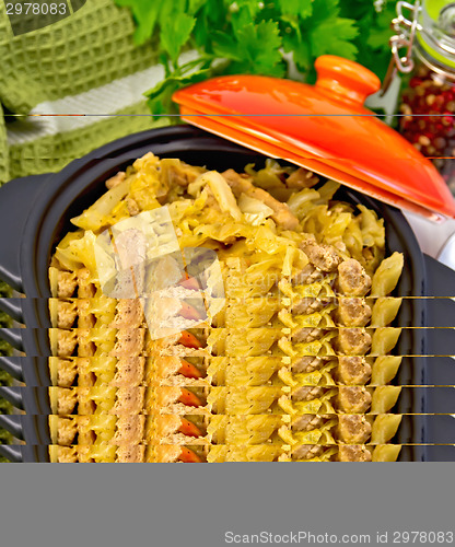 Image of Cabbage stew with meat in black pot on board