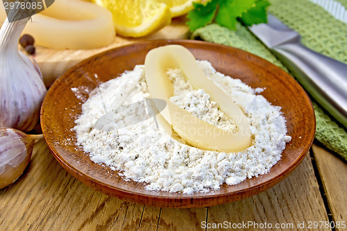 Image of Calamari ring in flour on board