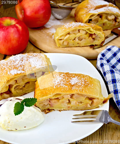 Image of Strudel with apples and ice cream with napkin on board