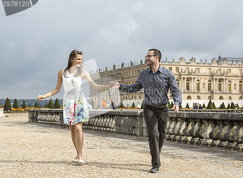 Image of Happy Young Couple Running Holding Hands
