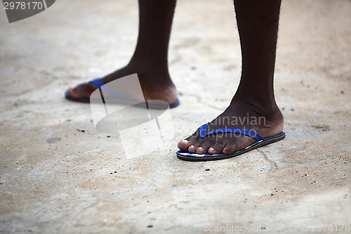 Image of Feet of an African man in blue flip flops