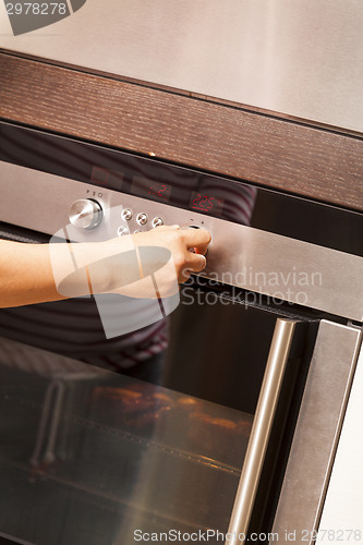 Image of Close Up of Hand Turning Knob on Oven