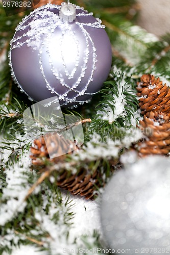 Image of Silver Christmas bauble on a tree with snow