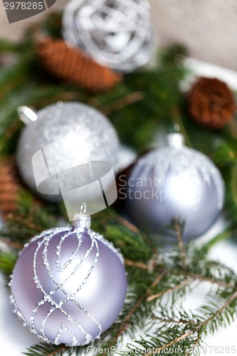 Image of Silver Christmas ornaments in leaves