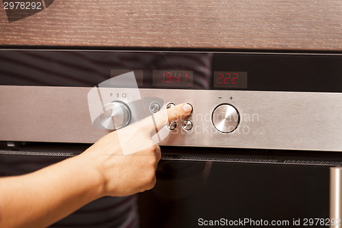 Image of Close Up of Hand Turning Knob on Oven