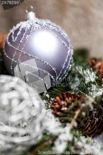 Image of Silver Christmas bauble on a tree with snow