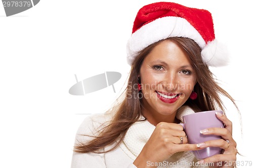 Image of Cold young woman in a Santa hat sipping coffee tea