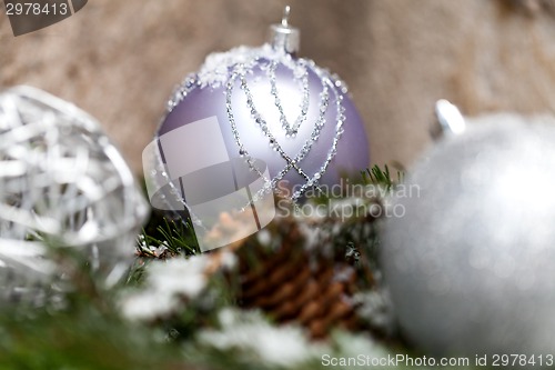 Image of Silver Christmas bauble on a tree with snow