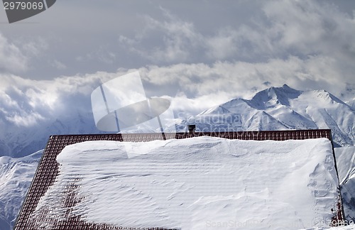 Image of Snowy roof and mountains in clouds