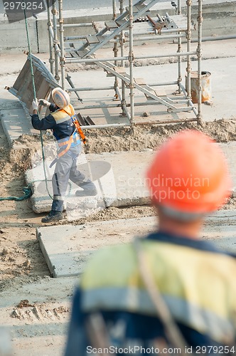 Image of Worker levels provision of plate lifting by crane