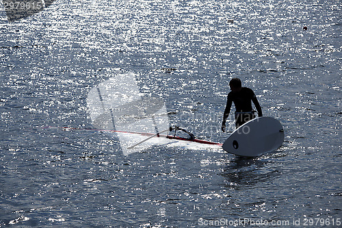 Image of kitesurfer stands in water