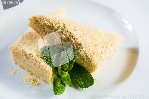Image of Cake Napoleon of puff pastry with sour cream on a plate.