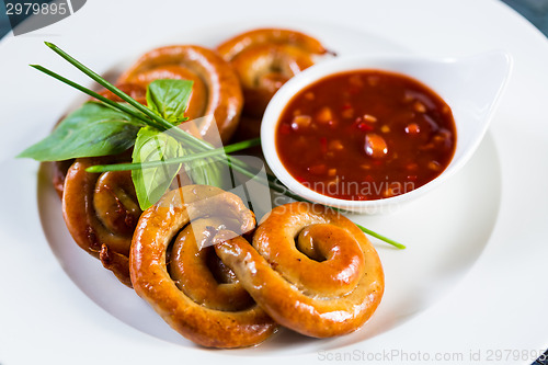 Image of organic grilled sausages on a white plate.