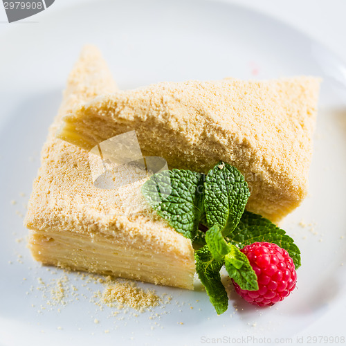 Image of Cake Napoleon of puff pastry with sour cream on a plate.