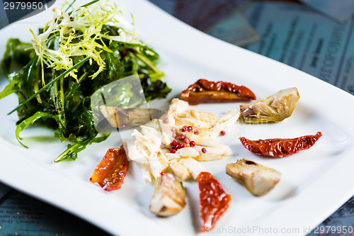 Image of Fresh salad with sun-dried tomatoes and cheese in the Italian style.