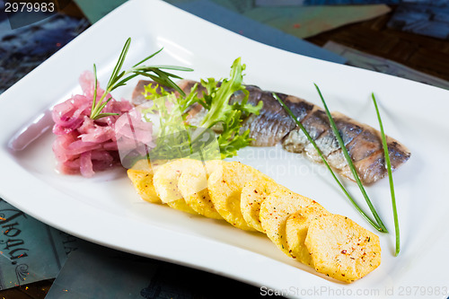 Image of Herring with fried potatoes and red onions