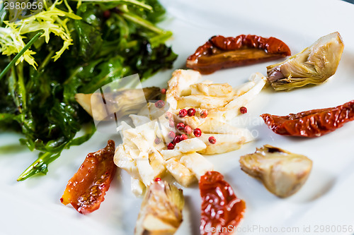 Image of Fresh salad with sun-dried tomatoes and cheese in the Italian style.