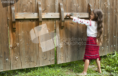 Image of Little girl opens the gate