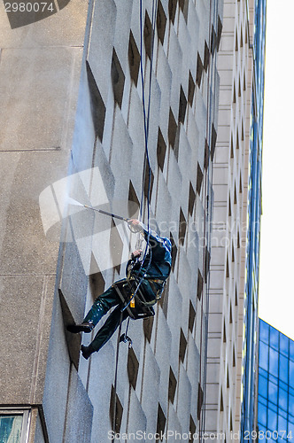 Image of Washer wash the windows of modern skyscraper, high risk work