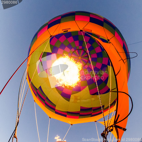 Image of Fire heats the air inside a hot air balloon at balloon festival 