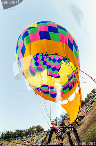 Image of Fire heats the air inside a hot air balloon at balloon festival 