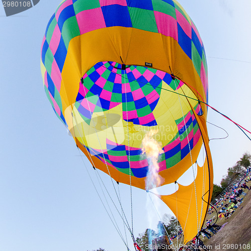 Image of Fire heats the air inside a hot air balloon at balloon festival 