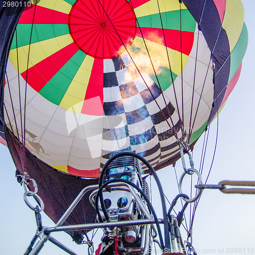 Image of Fire heats the air inside a hot air balloon at balloon festival 