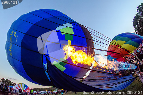 Image of Fire heats the air inside a hot air balloon at balloon festival 