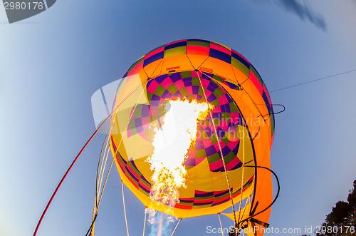 Image of Fire heats the air inside a hot air balloon at balloon festival 