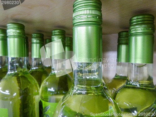 Image of wine bottles stacked on wooden racks shot with limited depth of 