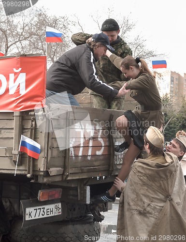 Image of Girl in form of World War II times rises in truck