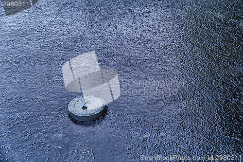 Image of manhole cover in asphalt