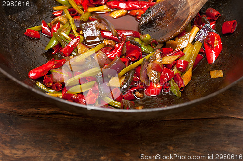 Image of fried chili pepper and vegetable on a wok pan