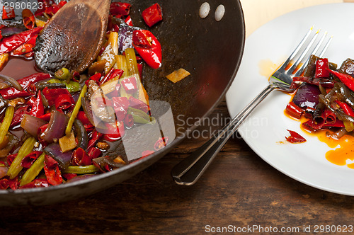 Image of fried chili pepper and vegetable on a wok pan