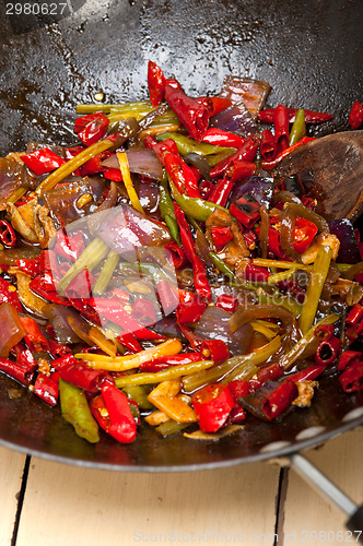 Image of fried chili pepper and vegetable on a wok pan