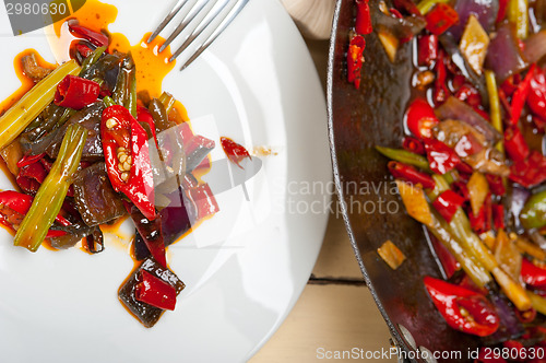 Image of fried chili pepper and vegetable on a wok pan