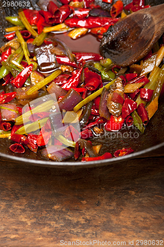 Image of fried chili pepper and vegetable on a wok pan