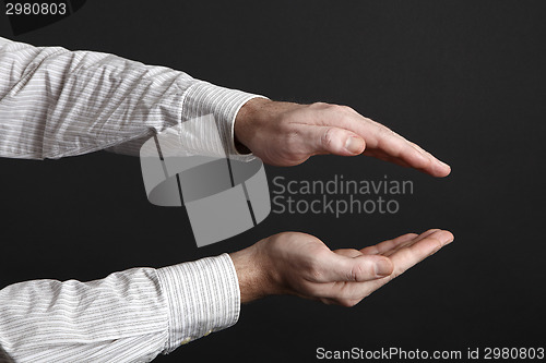 Image of Caucasian male hands protect something