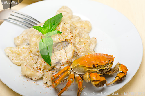 Image of Italian gnocchi with seafood sauce with crab and basil