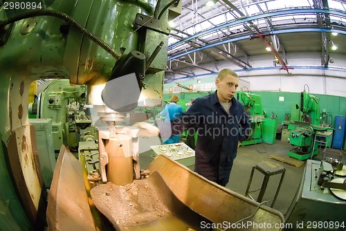 Image of Young milling-machine operator works at machine