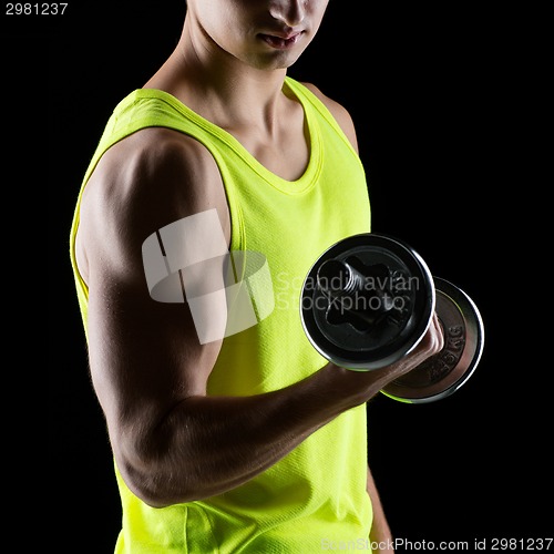 Image of close up of young man with dumbbell