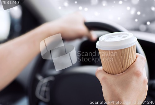 Image of close up of man drinking coffee while driving car