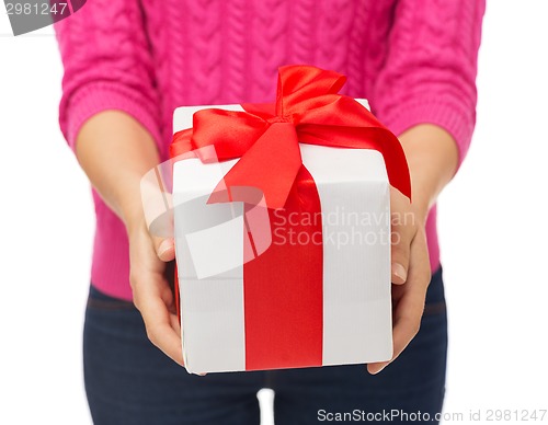 Image of close up of woman in pink sweater holding gift box