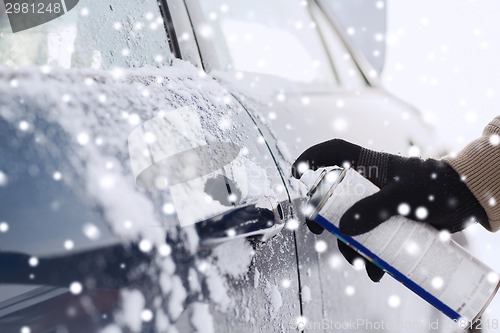 Image of closeup of man hand with lock door de-icer