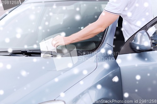 Image of close up of man with parking ticket on car