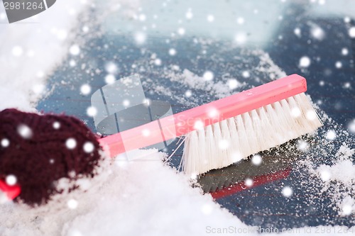 Image of closeup of woman cleaning snow from car