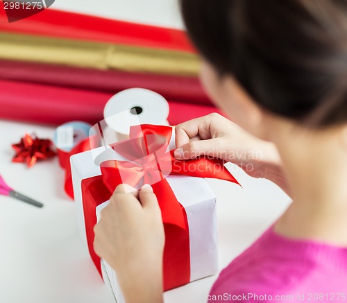 Image of close up of woman decorating christmas presents