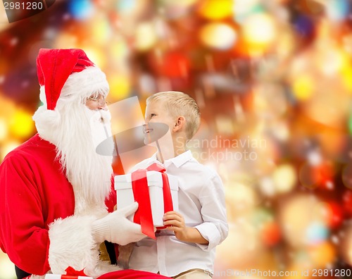 Image of smiling little boy with santa claus and gifts
