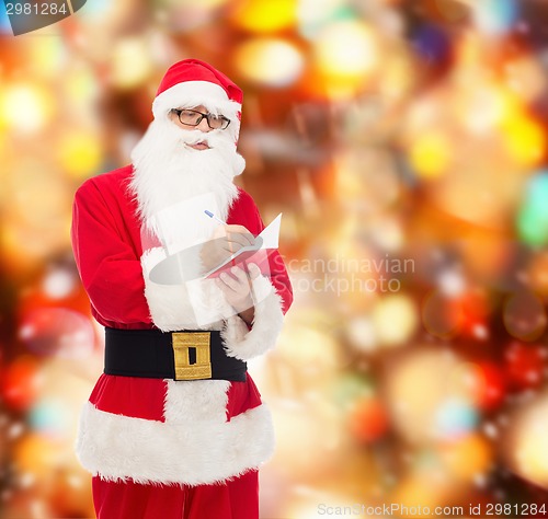 Image of man in costume of santa claus with notepad