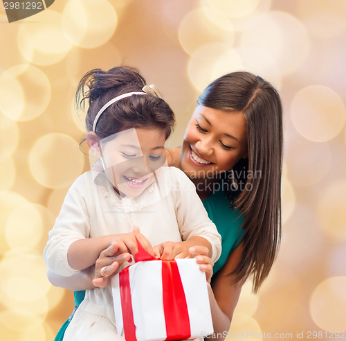 Image of happy mother and little girl with gift box